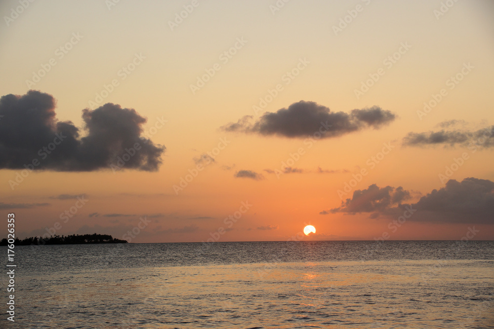 Sun setting on horizon over the ocean 