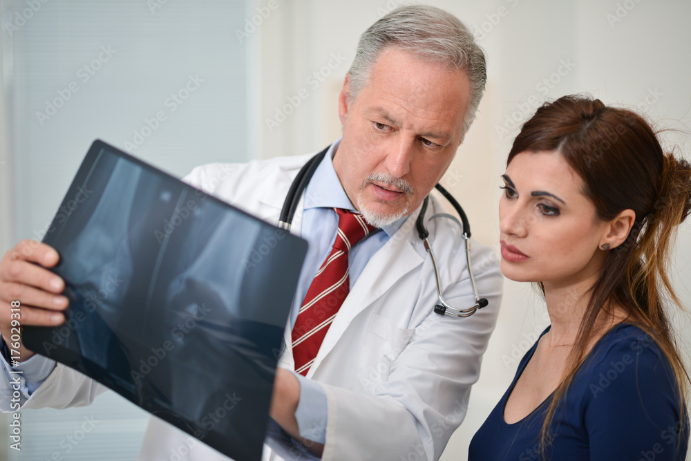 Doctor showing a radiography to his patient Doctor showing a radiography to his patient