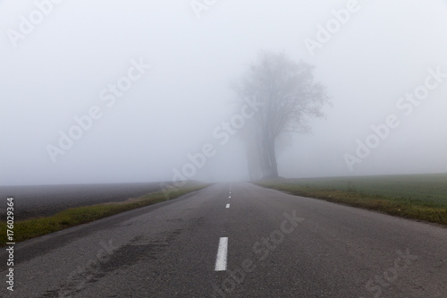 Asphalt road into the fog