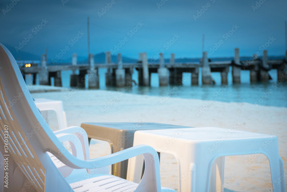 chair on beach of relaxing lake at sunset