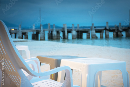 chair on beach of relaxing lake at sunset