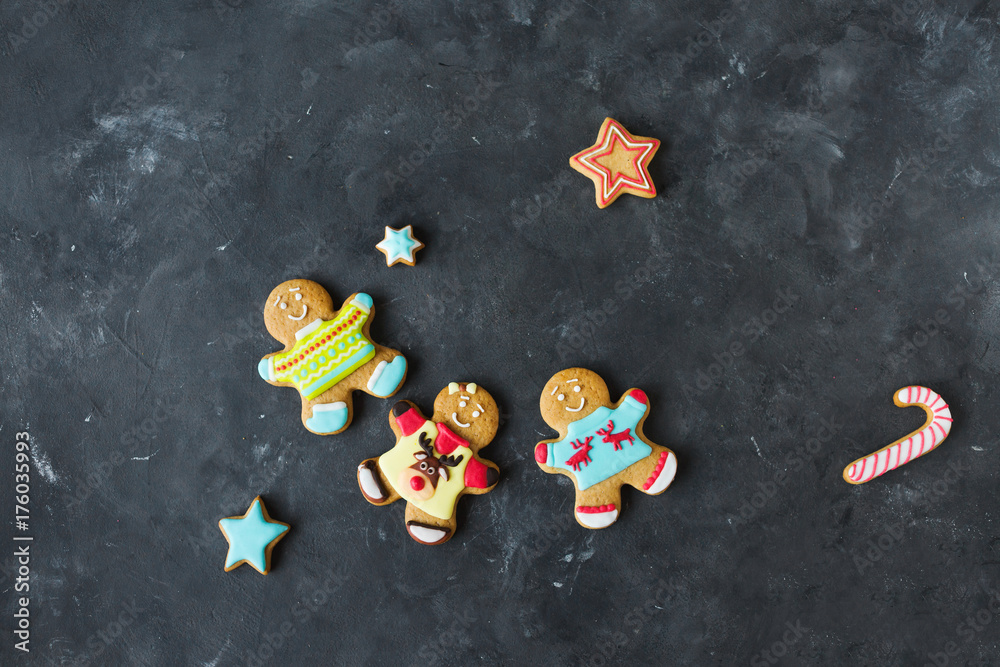 Ginger men with colored glaze on a gray background .. Gingerbread. Christmas cookies. Ginger man in a colored sweater