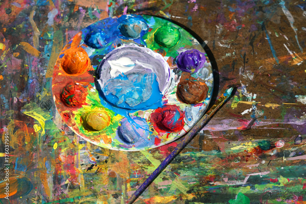 Fototapeta premium Round watercolor palette and paint brush on the board with color