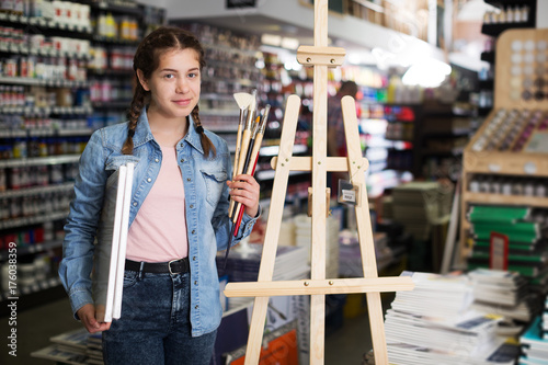 Girl standing among art supplies