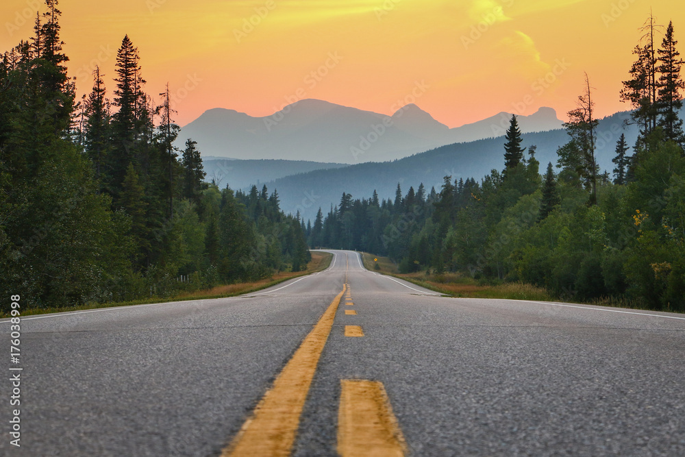 Fototapeta premium Zachód słońca nad drogą i górami, południowa Kanada