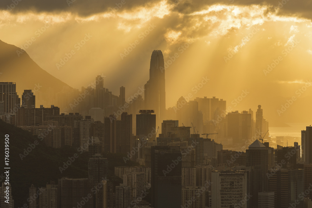 Silhouette of skyline of Hong Kong city with sun ray under sunset