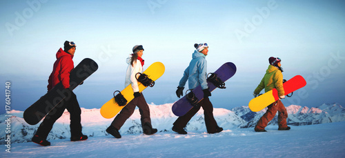 Group of snowboarders on top of the mountain.