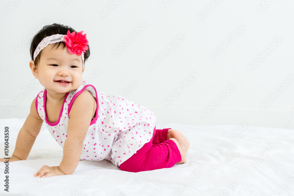 Portrait of adorable baby crawling on a white floor with head band Portrait of adorable baby crawling on a white floor with head band