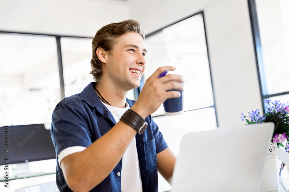 Fototapeta premium Young businessman in office with a mug