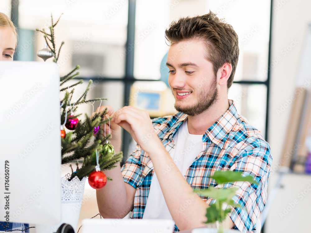 Portrait of smiling office worker with little Christmas tree