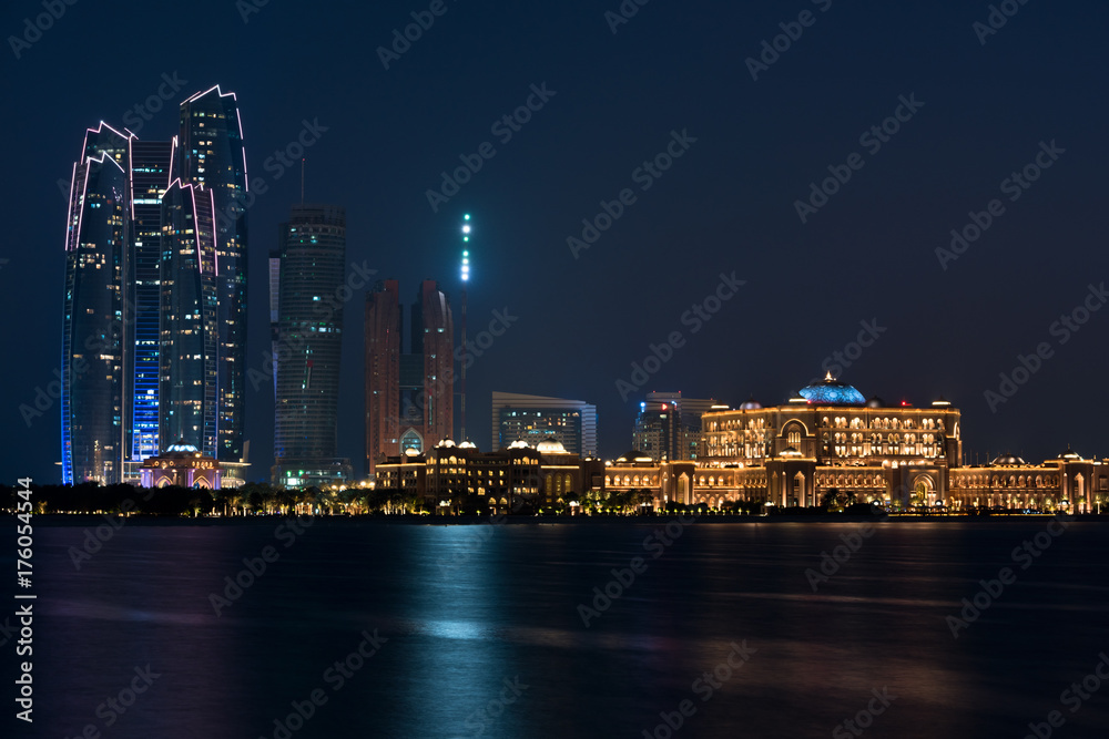 Fototapeta premium Abu Dhabi buildings skyline from the sea at night