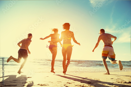 Happy friends run sunset beach holidays