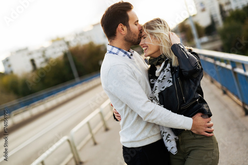 Happy young couple hugging and kissing on bridge © NDABCREATIVITY