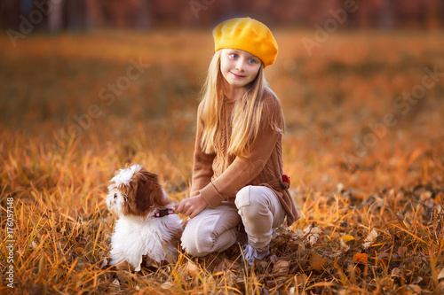 Girl with her beloved puppy in autumn park. Close.