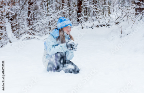 girl enjoying day playing in winter forest