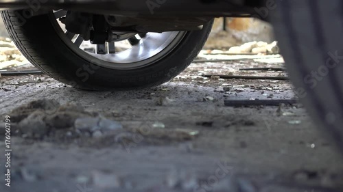 Close up view of standard vehicle tires on the muddy grungy ground.  Panning effect.