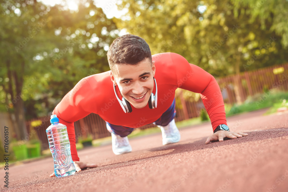 Sport fitness man push-ups. Male athlete exercising push up outside in