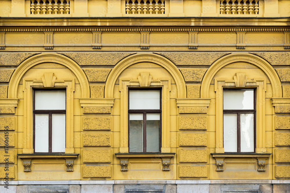 Fototapeta premium Old decorative building, yellow colored, with tree windows