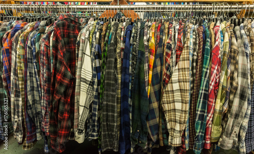 Obraz na płótnie Used flannel shirts hanging on a clothing rail in a thrift store