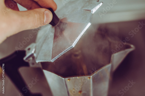 Making coffee with a percolator : steamy caffeine drink with hand making it photo