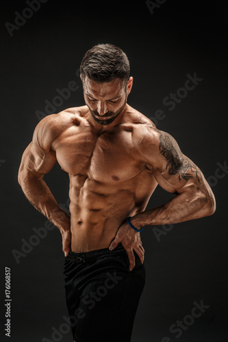 Very brawny guy bodybuilder posing. Beautiful sporty guy male power. Fitness muscled man.