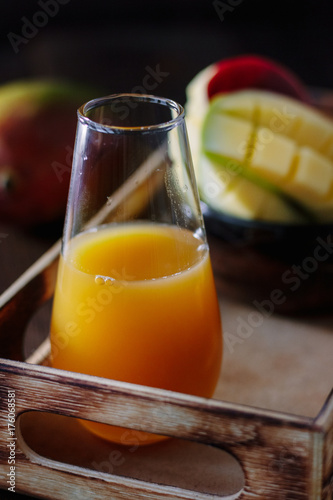Glass with fresh mango juice in wooden box