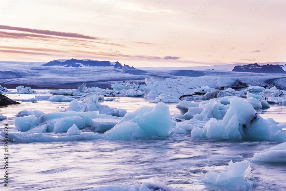 Sunset in the glacial lagoon. Floating on the water ice pieces and a beautiful sunset sky. Long exposure. Iceland. Country of ice and fire.
Sunset in the glacial lagoon. Floating on the water ice pieces and a beautiful sunset sky. Long exposure. Iceland. Country of ice and fire.