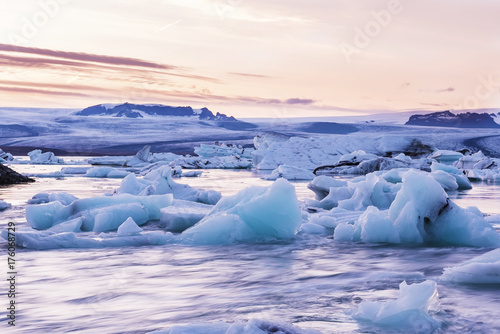 Sunset in the glacial lagoon. Floating on the water ice pieces and a beautiful sunset sky. Long exposure. Iceland. Country of ice and fire. 