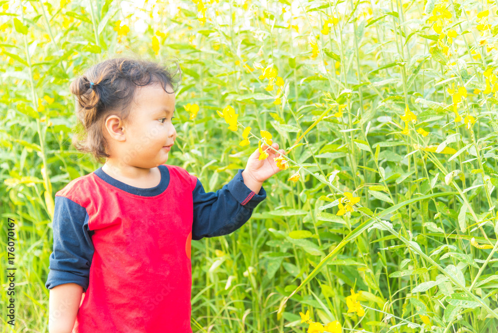 Little girl smiling at camera in the garden. Little girl smiling at camera in the garden.
