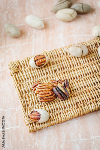 Nice pecan nuts over pink plastic board.