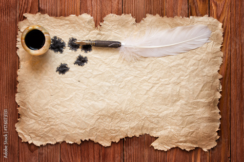 Inkwell and feather on a ba...