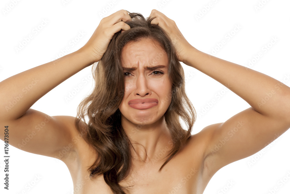 Beautiful young woman has an itch in her hair on white background