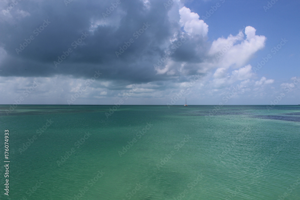 Obraz premium Una grossa nuvola scura porta l'ombra sul mare cristallino verde del Belize