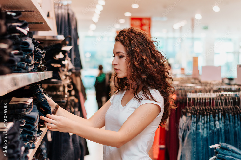Young girl in shop buying clothes. Young girl in shop buying clothes.