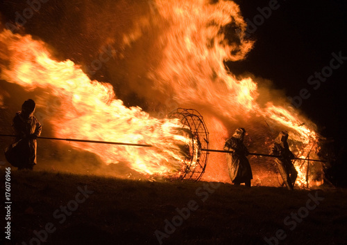 Feuerrad wird mit lodernden Flammen zum Winterende den Hügel hinab gerollt