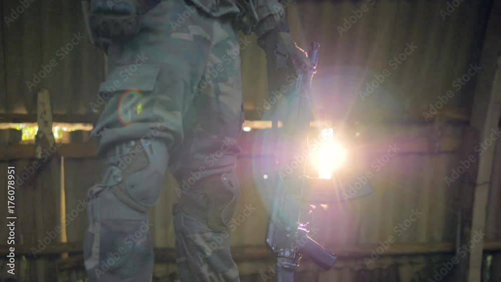 Light beams on a resting military with rifle. 4K. Stock Video | Adobe Stock
