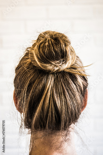 Head of a young woman from behind. Hair bun