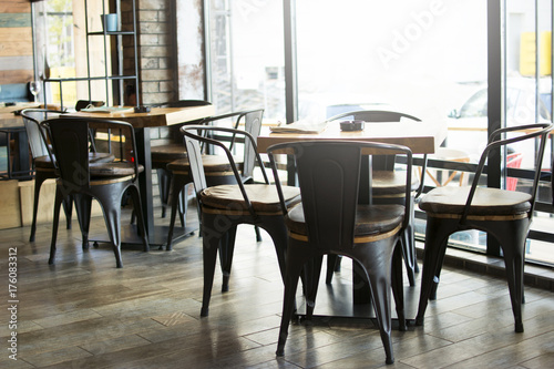 Interior of a modern urban cafe in the morning sunlight. Beautiful interior of a modern industrial style bar.