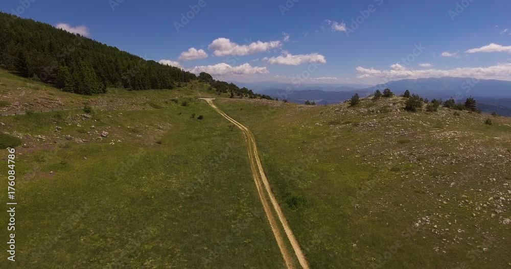 Aerial, green mountains with a road crossing it in summer in Italy, 4K