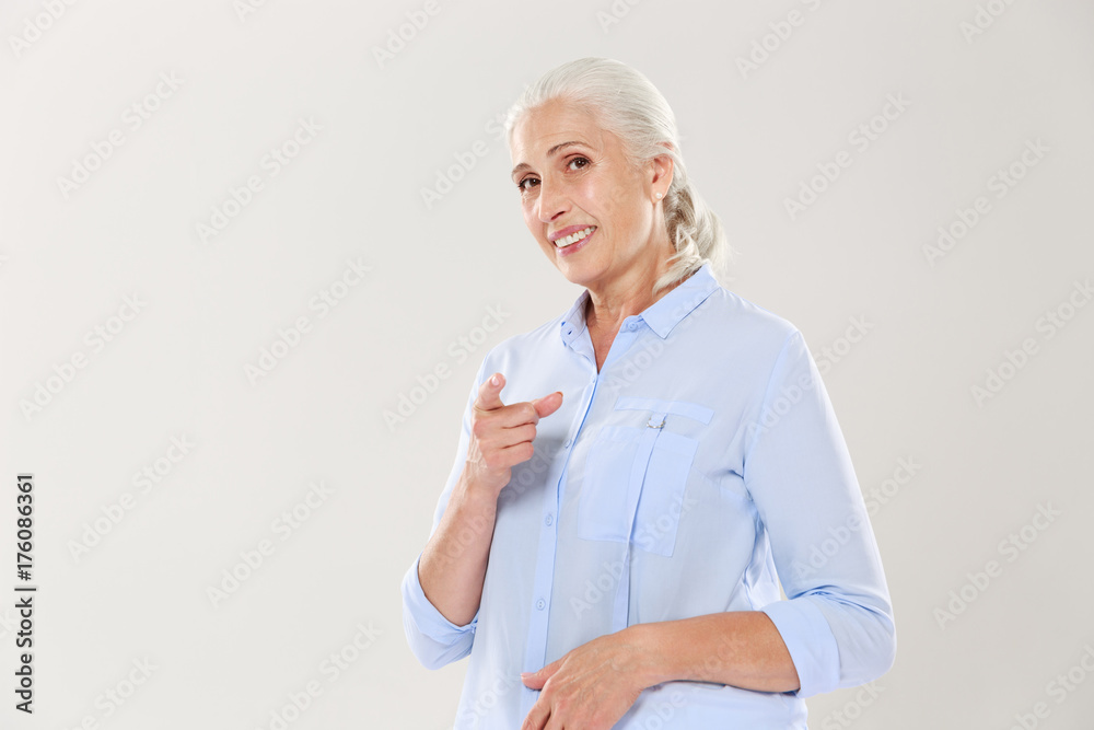 Portrait of smiling old woman pointing with finger to you Portrait of smiling old woman pointing with finger to you