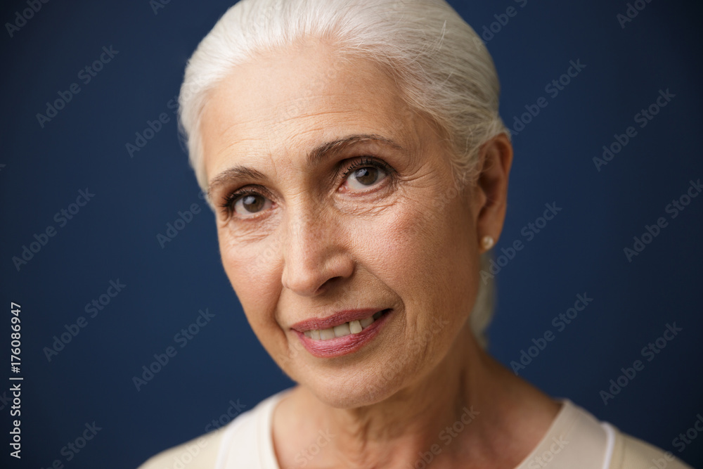 Close-up portrait of smiling mature caucasian woman, looking at camera