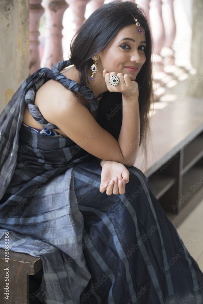 Indian woman sitting near window with smile on her face Indian woman sitting near window with smile on her face