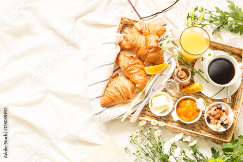 Fotografia Continental breakfast on white bed sheets - flat lay
