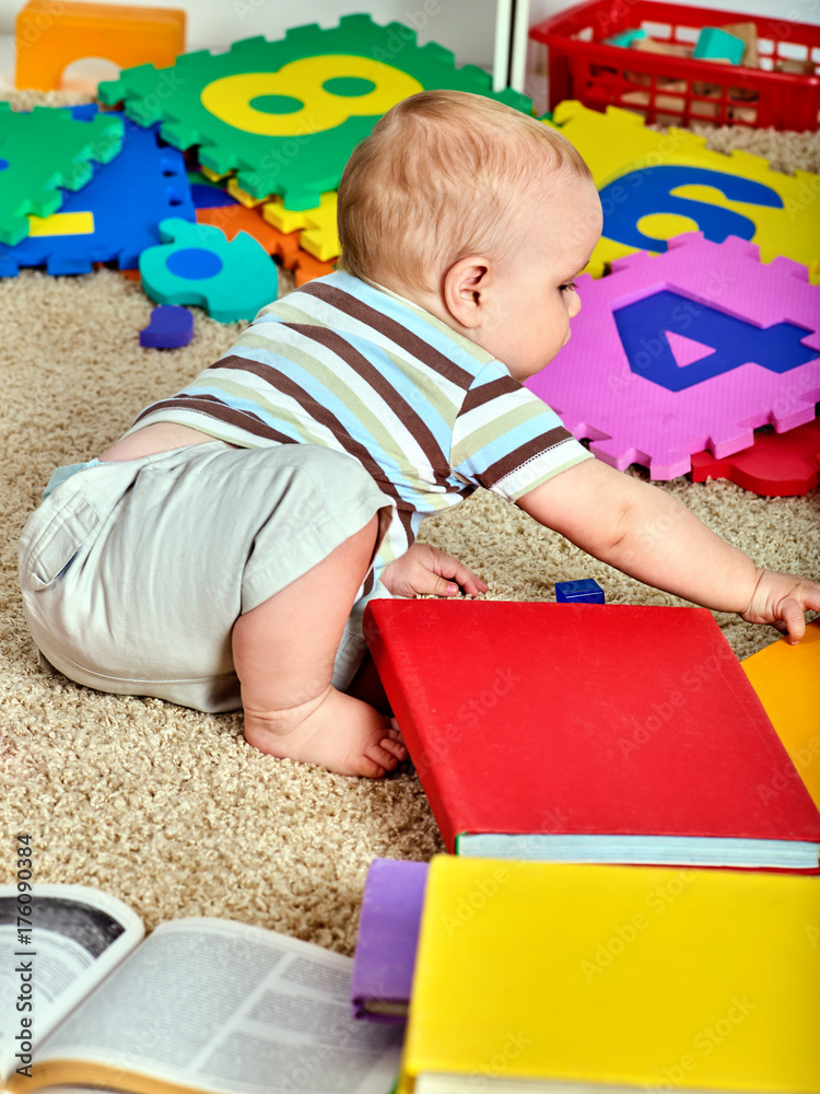 Child jigsaw develops children. Family puzzle making mother and baby. Mom  holding big pieces helping kid. Portrait of boy and mother top view. Kid  chews cube. Teaching child to reading. Stock Photo