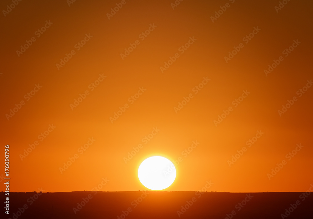 Beautiful sunset with orange sky and complete sun