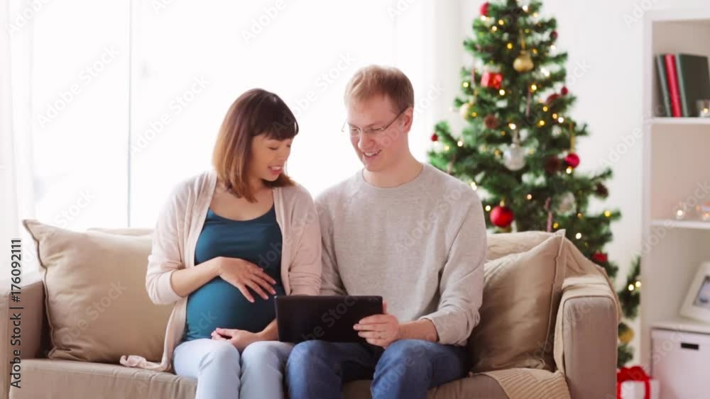 man and pregnant wife with tablet pc at christmas man and pregnant wife with tablet pc at christmas