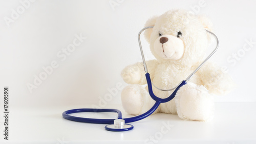 Teddy bear with a stethoscope. Pediatrician healthcare for children. Empty copy space for Editor's text. photo