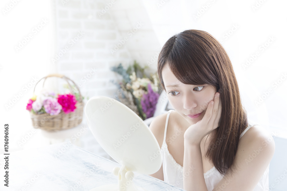 ビューティ　鏡を見る若い女性　ニキビ　肌荒れを点検