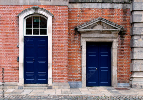 Canvas Print Blue closed doors on a brick facade of a building