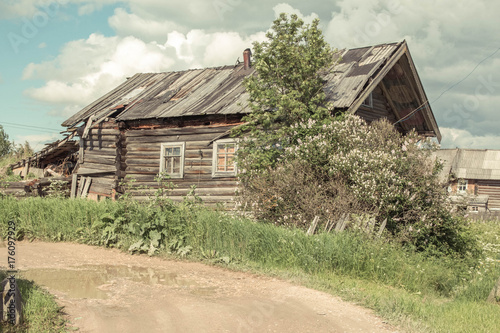 north Russian village Isady. Summer day, Emca river, old cottages on the shore, old wooden bridge. Abandoned building. photo